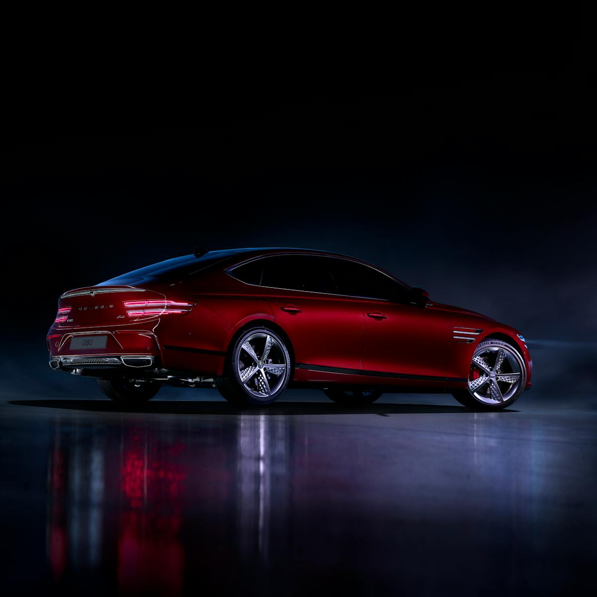 A stylish red luxury car displayed in a dramatic nighttime setting, showcasing its sleek design.