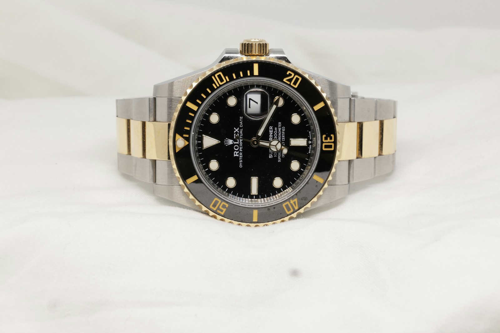 a black and gold rolex watch on a white background