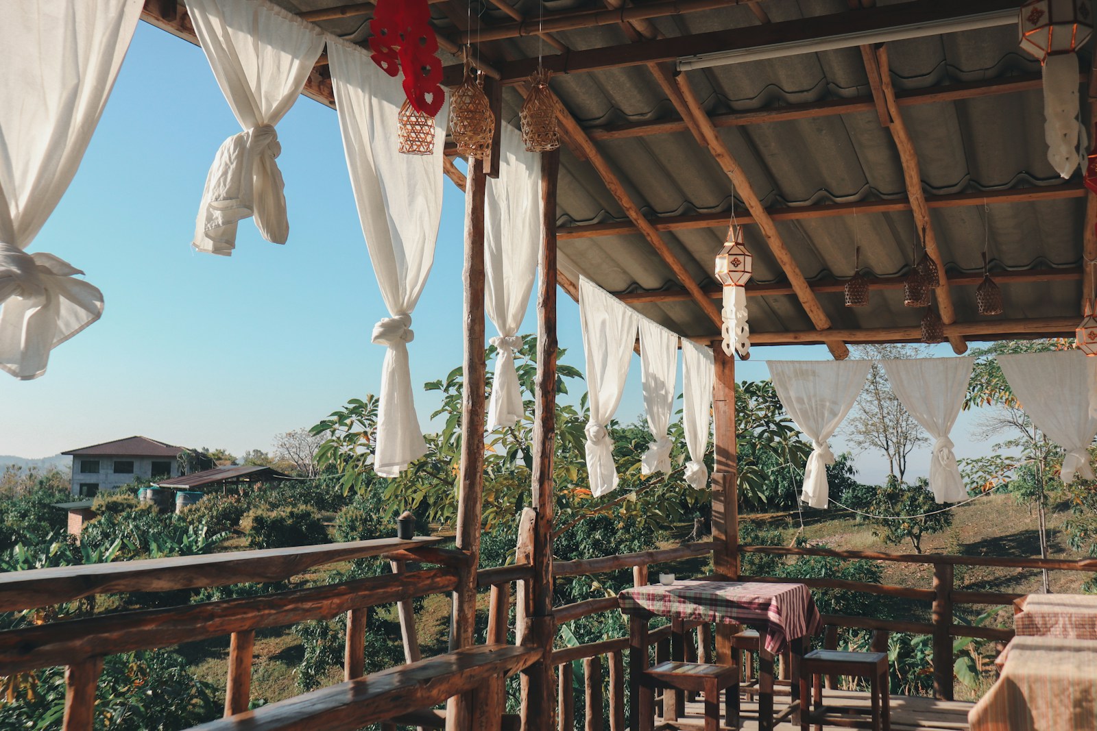a covered porch with a table and chairs